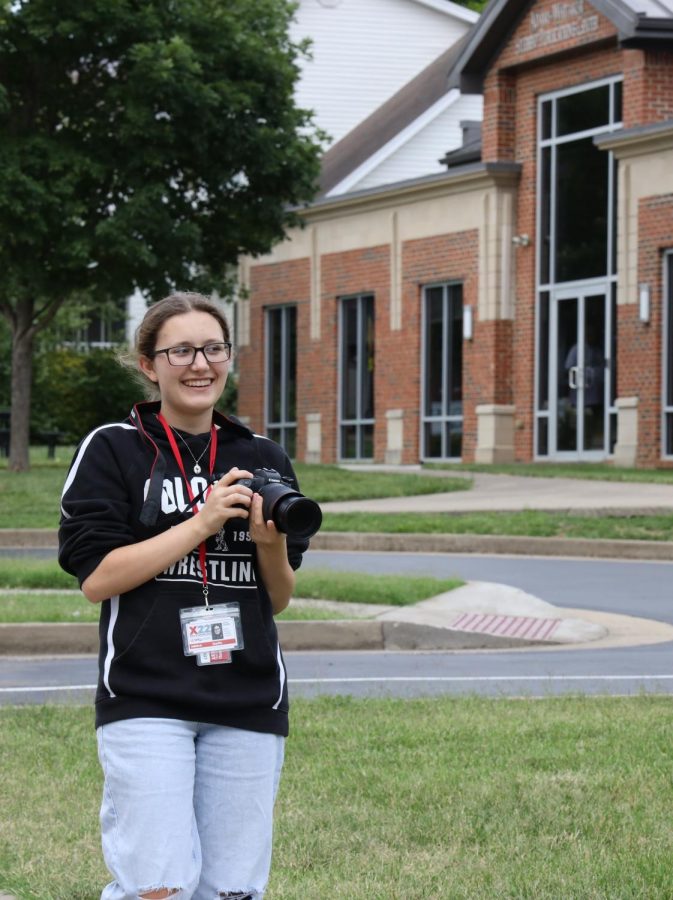 Jaylin Jaggers practicing photography with her camera outside of the student publications center.