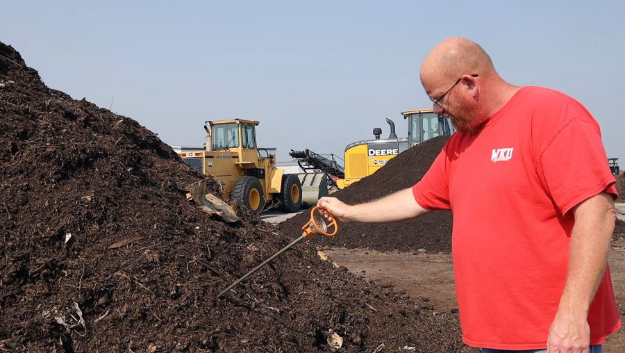 Joey Reynolds, an agriculture technician at the WKU Farm, sticks a thermometer into a compost mixture to check if it is the right temperature. (Photo by Tibni Valle/ Bowling Green High School)